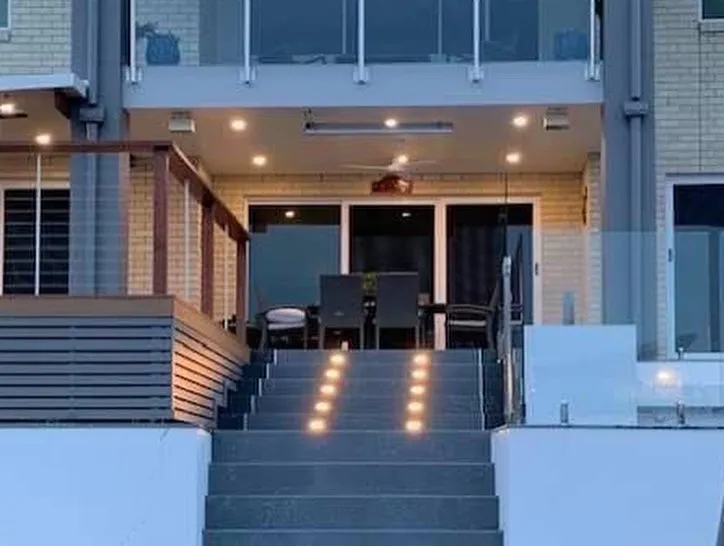 Modern building with illuminated staircase at dusk.